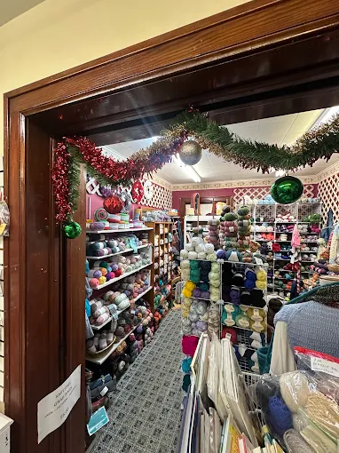 Colorful yarn shelves through a garland-decorated wooden doorway