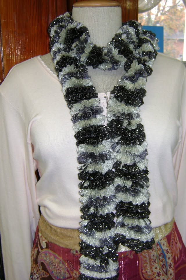 Black-and-pale-green ruffled scarf on a dress form