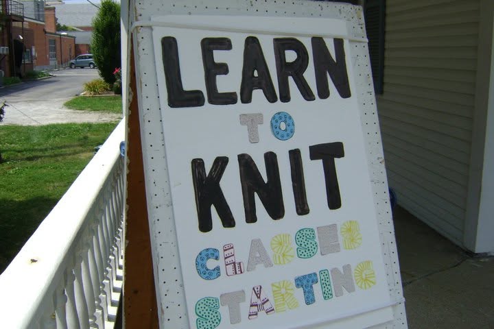 Handmade porch sign reading Learn to Knit, Classes Starting