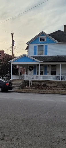 Blue-and-white shop building with a front porch