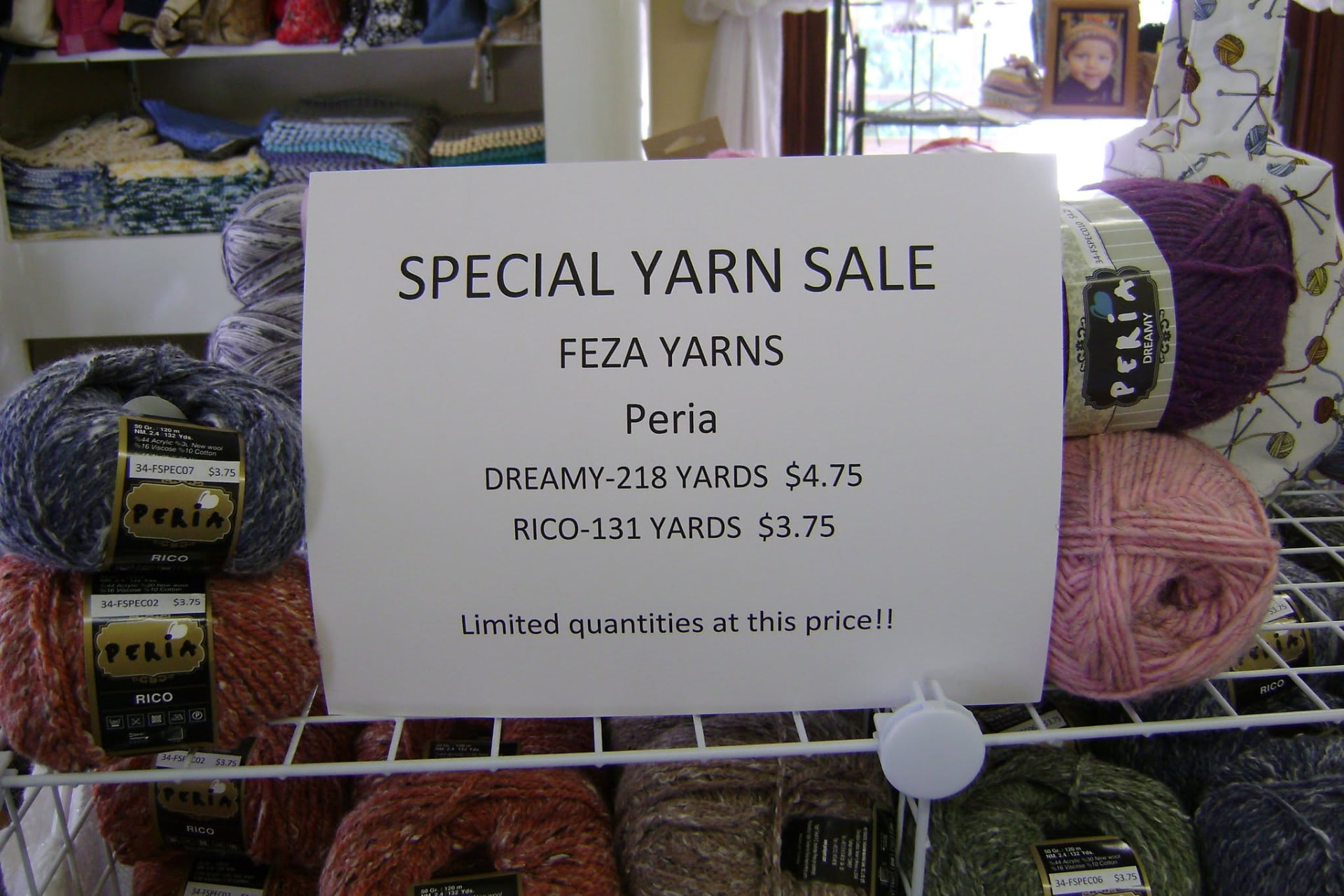 Yarn surrounding a Special Yarn Sale sign with photographed prices not confirmed as current